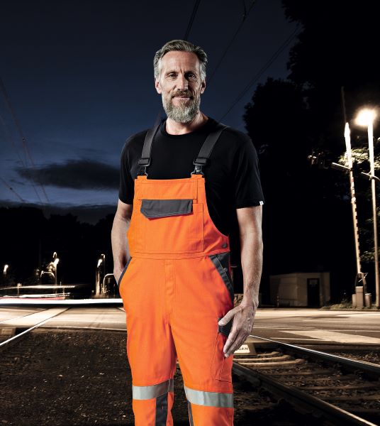 Un employé de la voie porte des vêtements de signalisation pendant le travail de nuit.